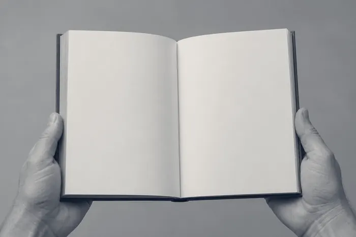 Two hands holding an open book with blank pages