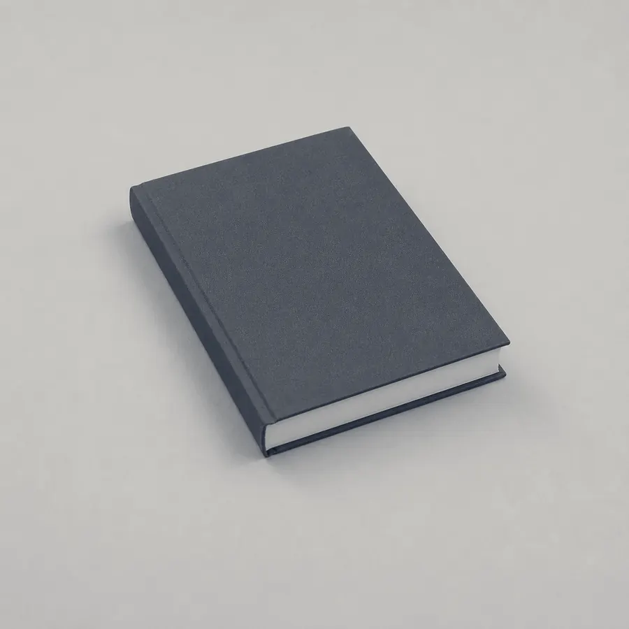 A closed dark hardback book on a pale surface