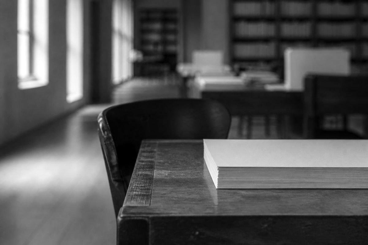 A desk with a stack of manuscripts in a quiet workroom